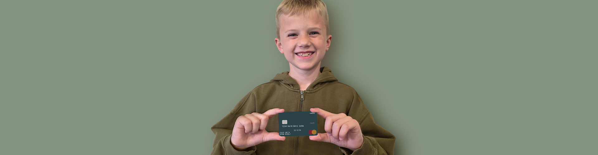 Young boy holding Famzoo debit card